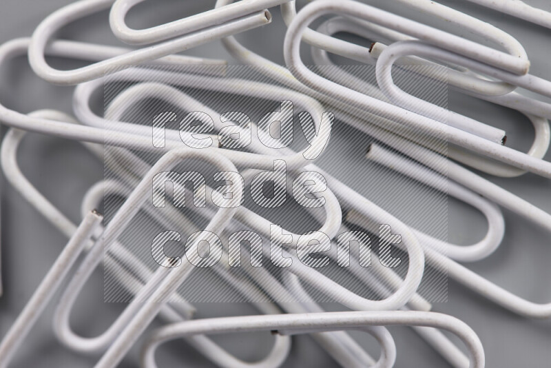 White paper clips isolated on a grey background