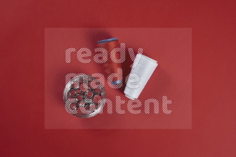 A white collection of sewing and tailoring tools arranged on a red background