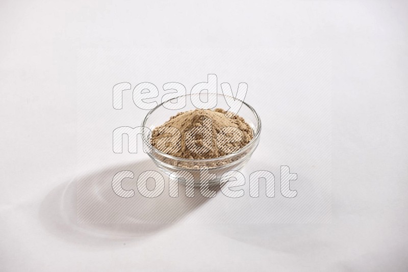 A glass bowl full of garlic powder on a white flooring in different angles