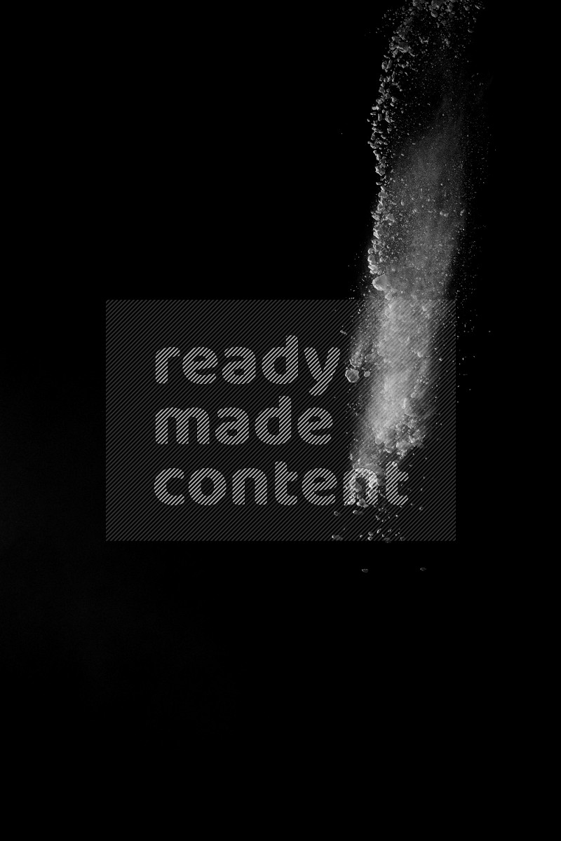 A side view of white powder explosion on black background
