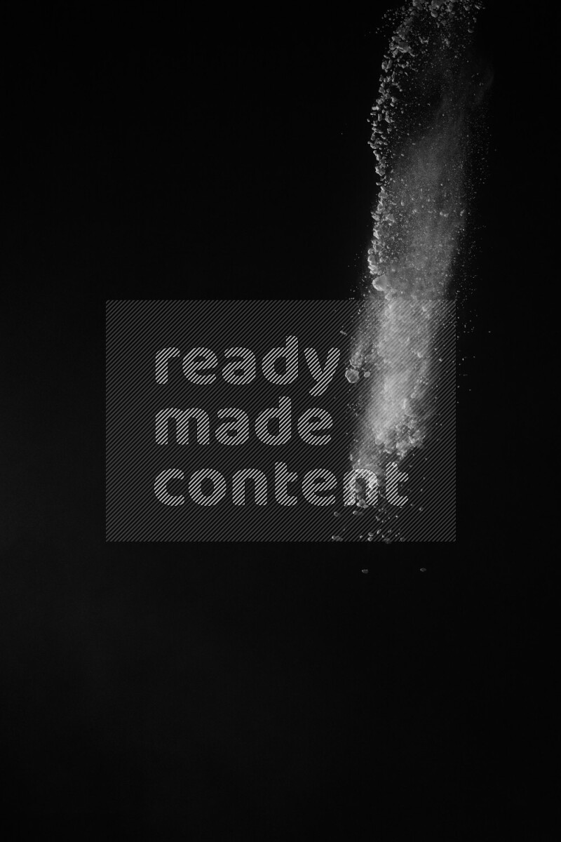 A side view of white powder explosion on black background