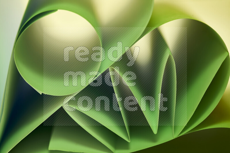 An artistic display of paper folds creating a harmonious blend of geometric shapes, highlighted by soft lighting in green tones