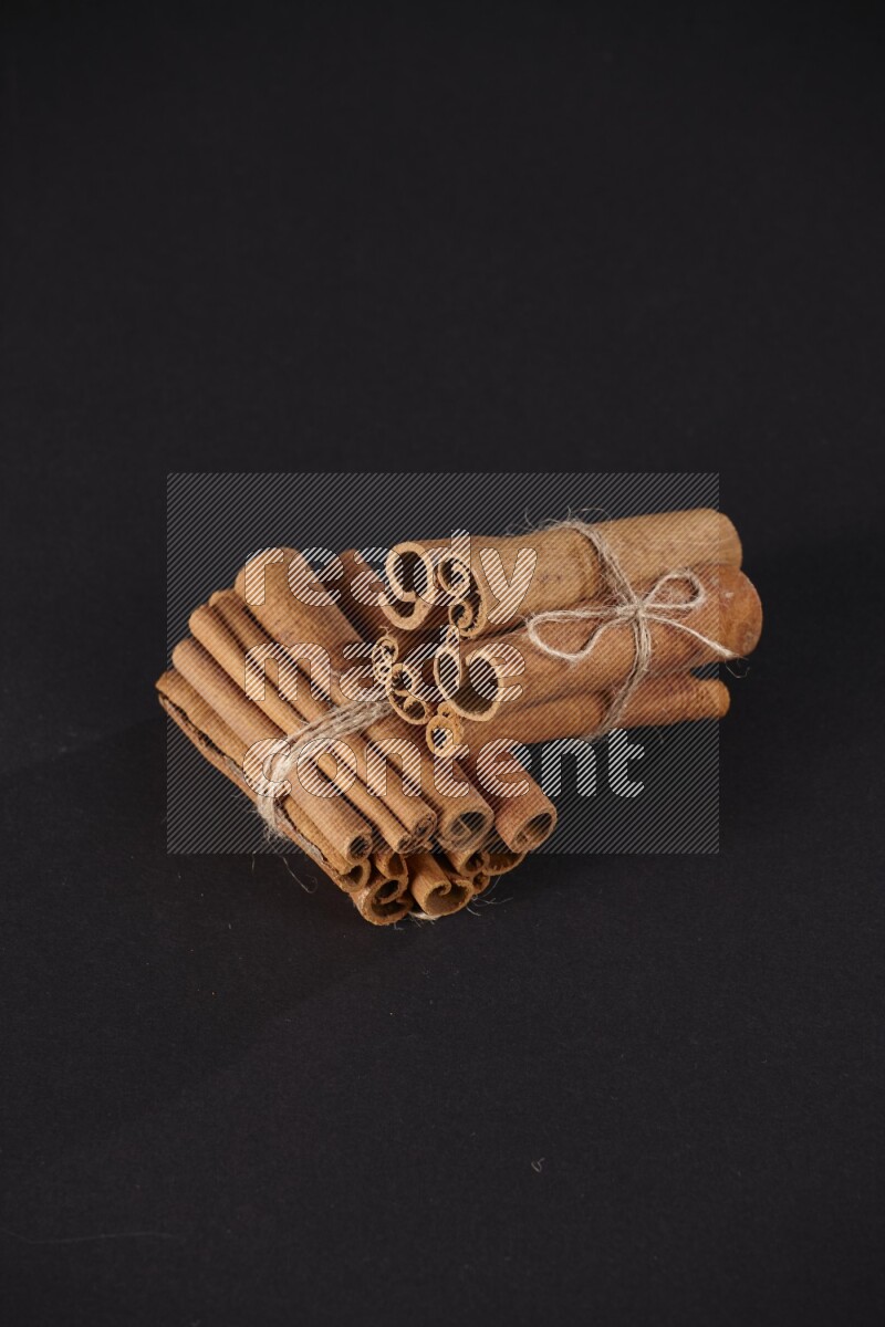 Two bounded stacks of cinnamon sticks on black background