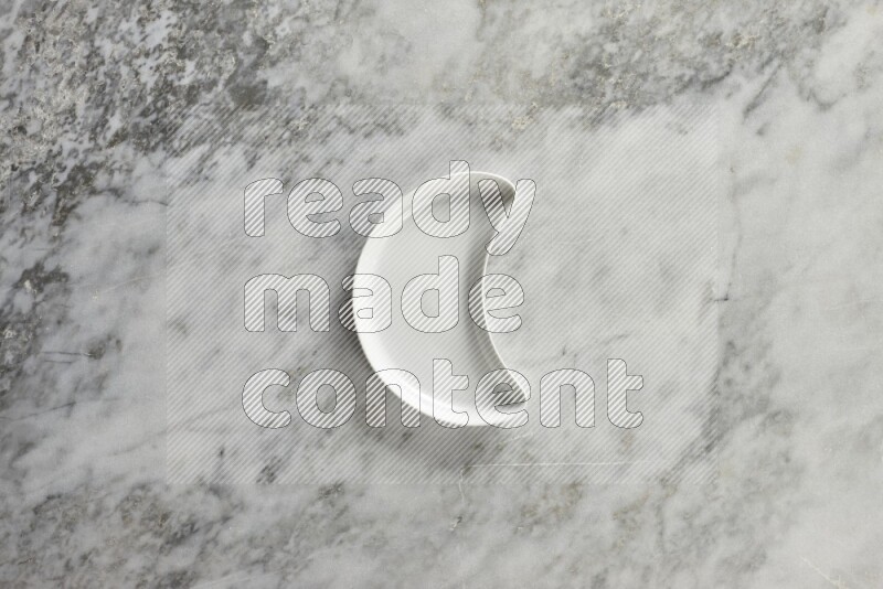 A pottery crescent plate on grey marble background