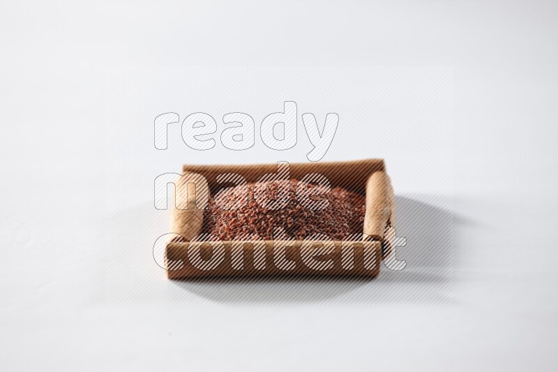 أربعة من أعواد القرفة مكونة شكل مربع بداخلها حب الرشاد علي خلفية بيضاء