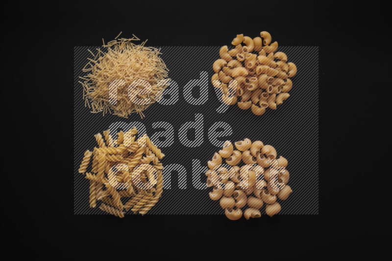 Different pasta types in bunches on black background