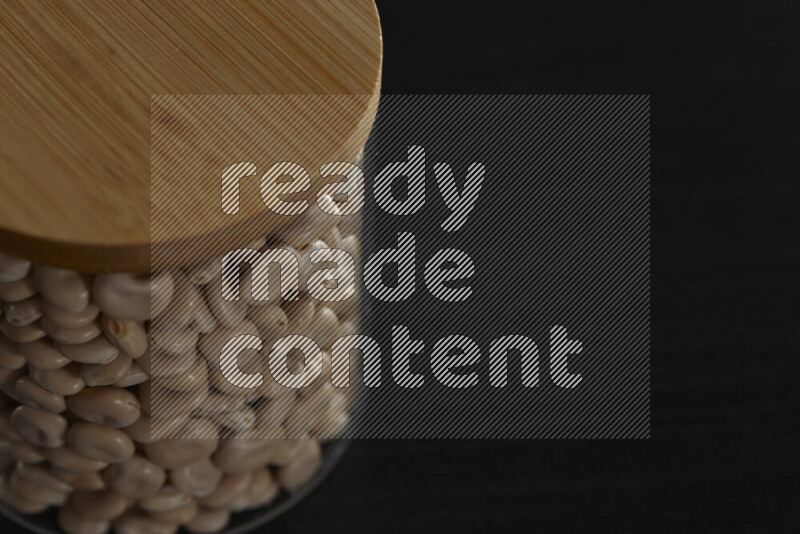 حبوب الترمس في وعاء زجاجي على خلفية سوداء