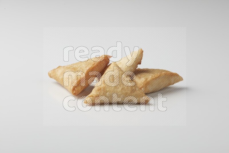 Four fried sambosas on a white background