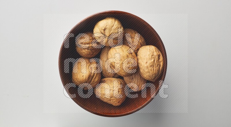 Top-view shot of walnut in a container on white background