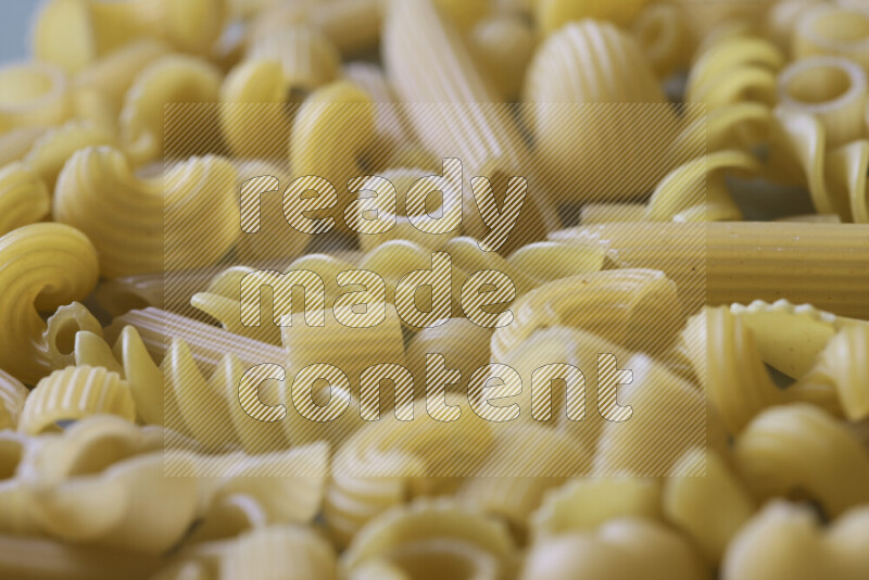 Different pasta types on light blue background