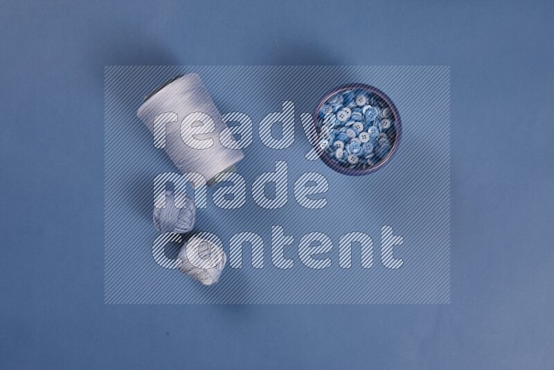 A blue collection of sewing and tailoring tools arranged on a blue background