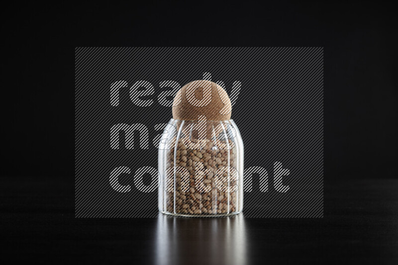 Black-eyed peas in a glass jar on black background
