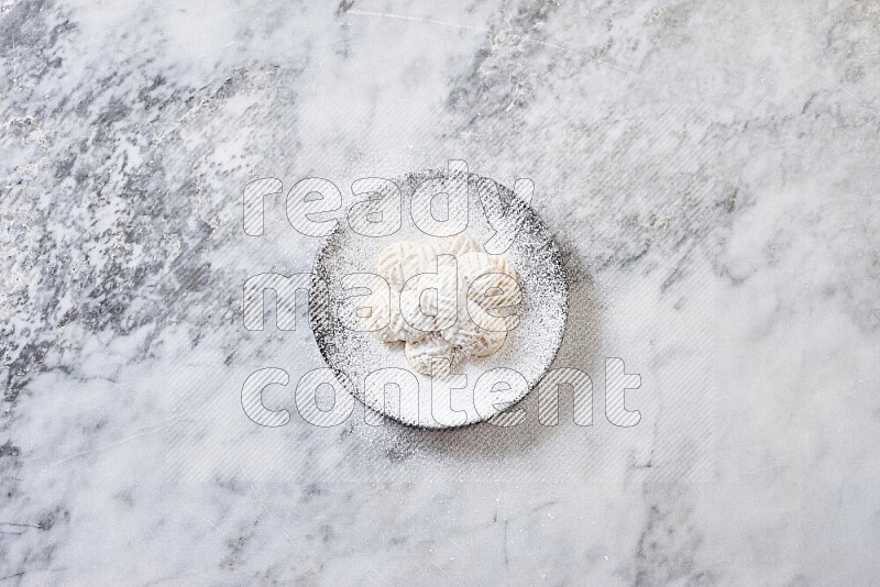 Kahk in black pottery plate on grey marble background