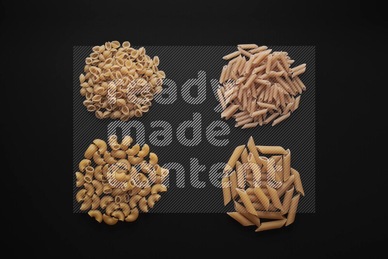 Different pasta types in bunches on black background