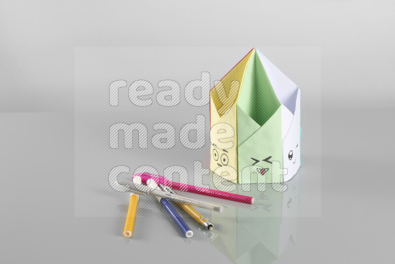 Origami pen holder on grey background