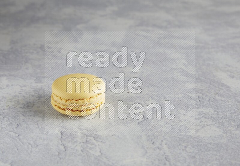 45º Shot of Yellow Vanilla macaron on white  marble background