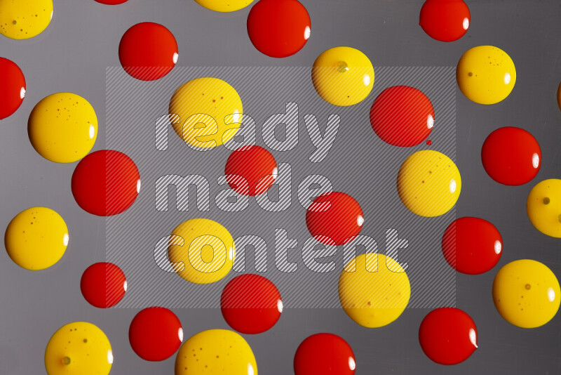 Close-ups of abstract red and yellow paint droplets on the surface