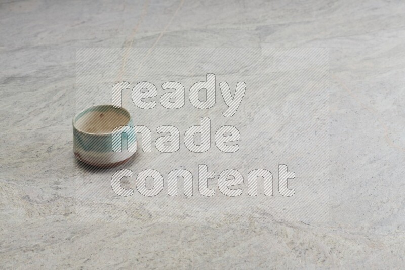 A multicolored pottery bowl on grey marble background