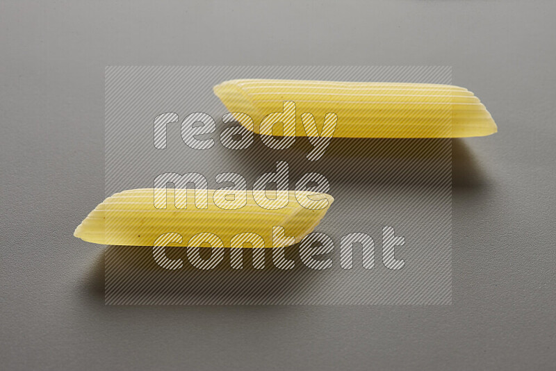 Penne pasta on grey background