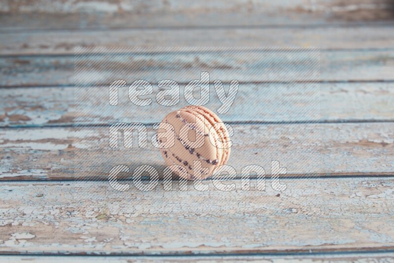 45º Shot of pink orange blossom macaron on light blue wooden background