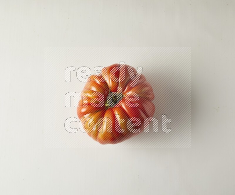 Single topview Heirloom tomato on a white backgrounds