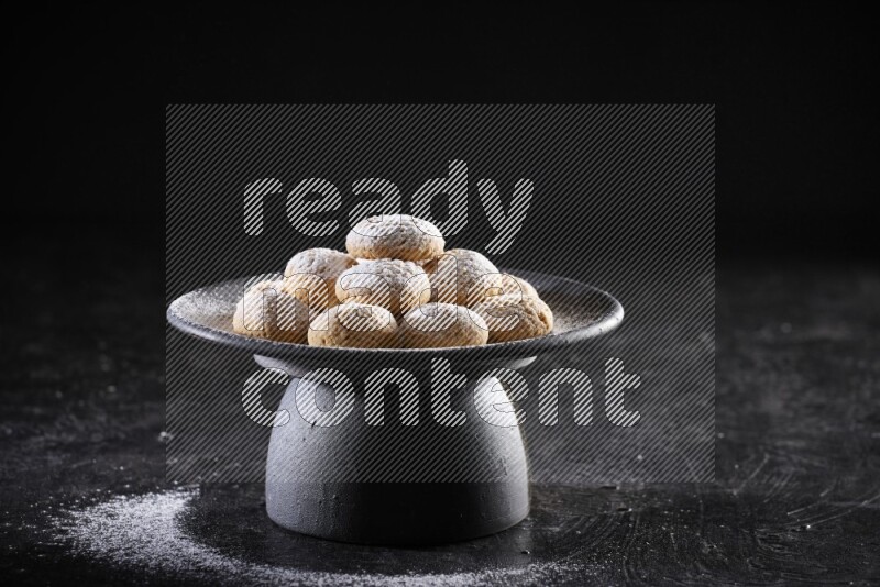 Kahk on a serving plate on a black background