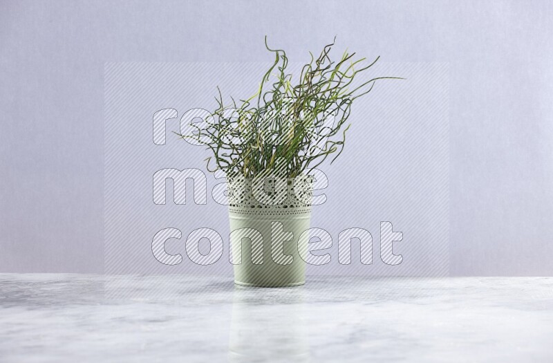 Artificial plant in green decorative pot on grey marble background