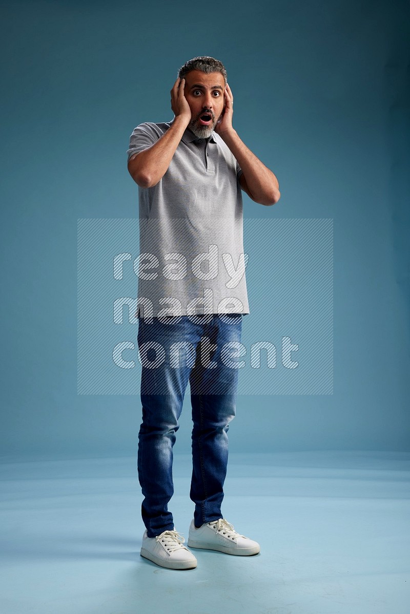 Man Standing Interacting with the camera on blue background