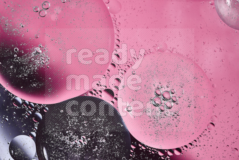 Close-ups of abstract oil bubbles on water surface in shades of black and pink