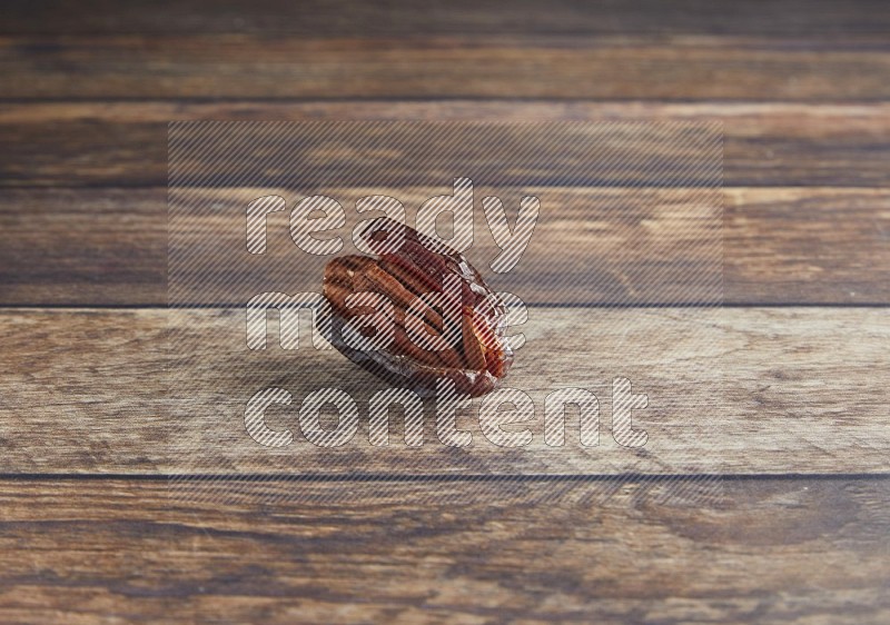 pecan stuffed madjoul date on a wooden background