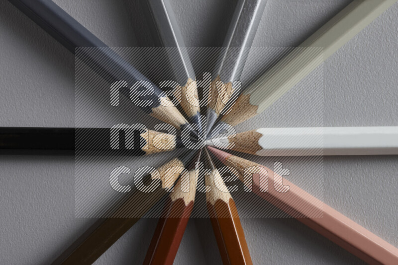 An arrangement of colored pencils in different colors on grey background