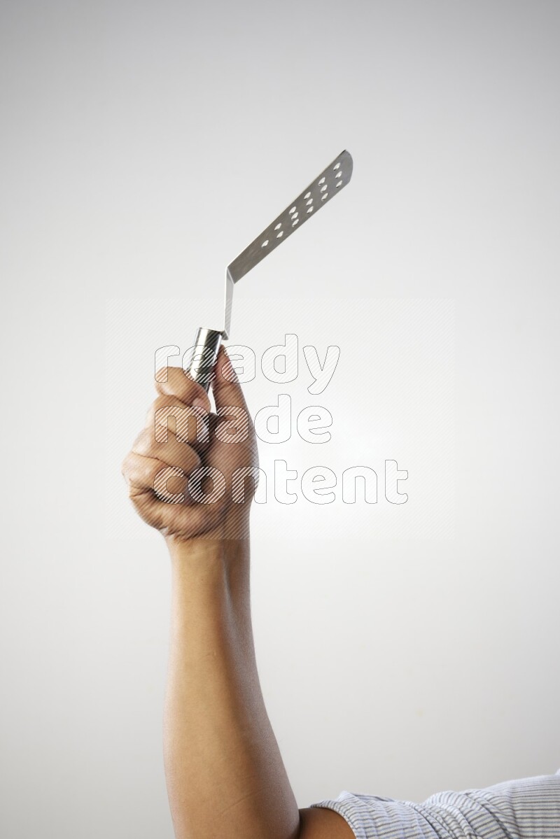 Male Hand Holding Burger Flipper on white background