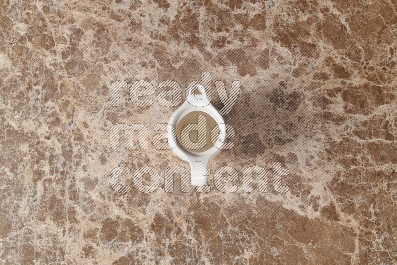 A ceramic milk jug on beige marble background