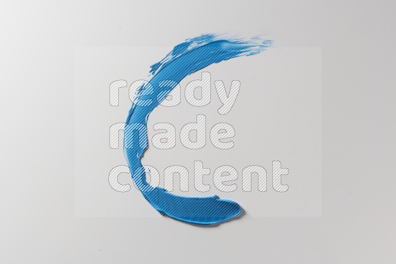 A blue single curved painting knife stroke on a white background