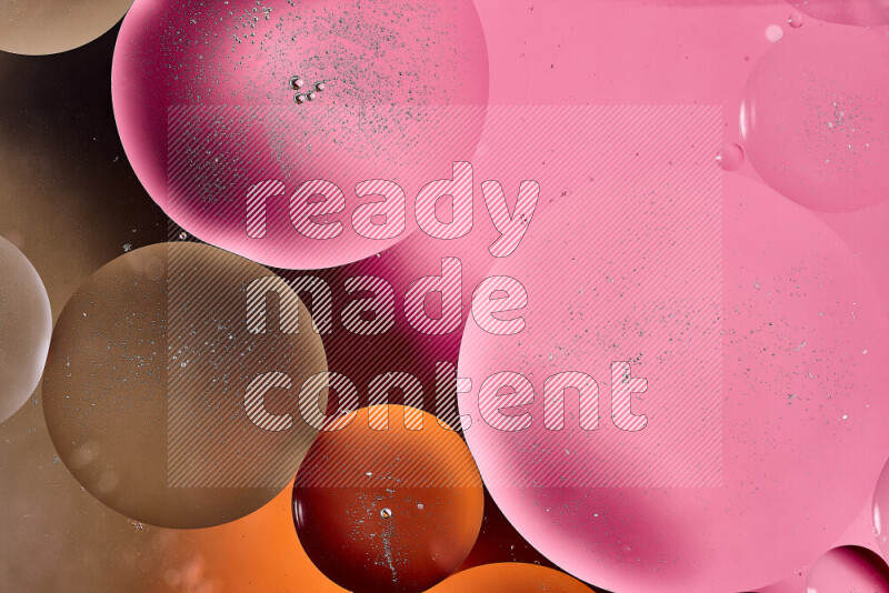 Close-ups of abstract oil bubbles on water surface in shades of brown, orange and pink