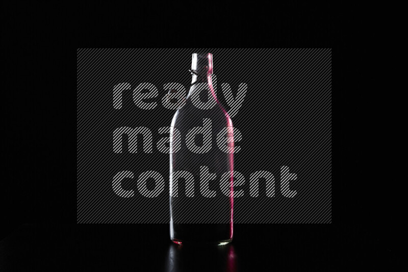 Water bottle with colored rim light against black background