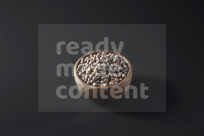 Chickpeas in a wooden bowl on grey background