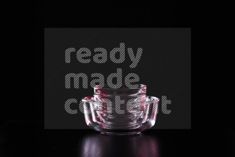 Glassware with rim light in red and white against black background