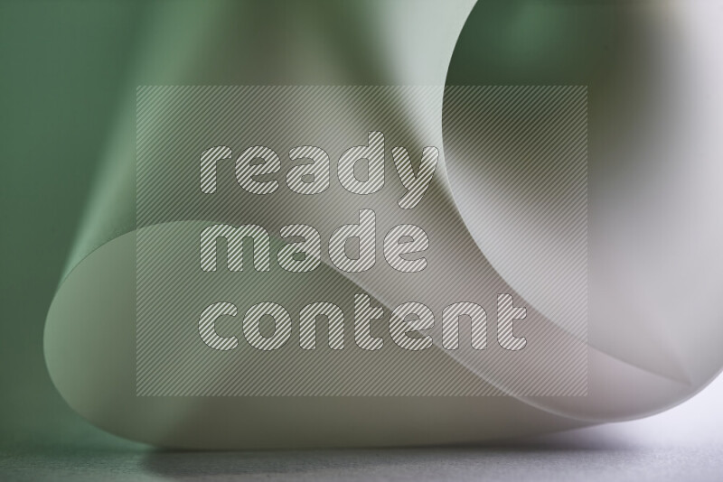 An abstract art piece displaying smooth curves in green and grey gradients created by colored light