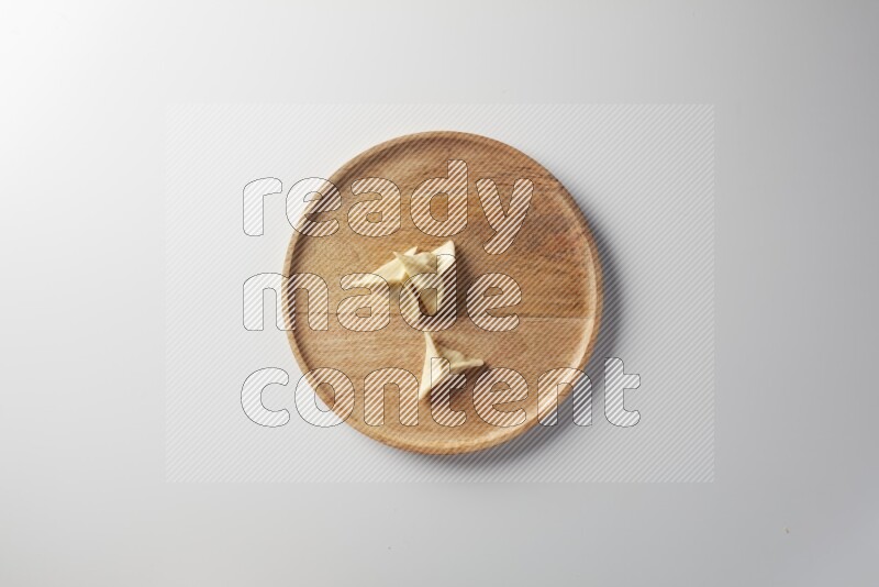 Three Sambosas on a wooden round plate on a white background