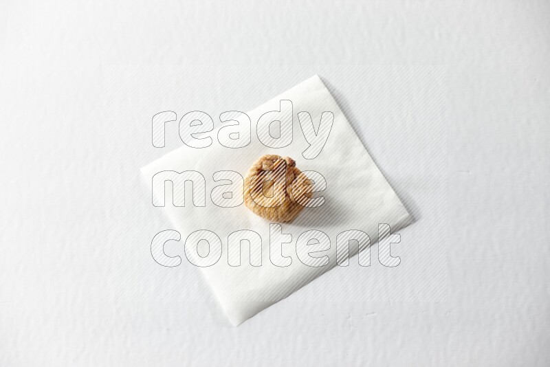 A dried fig on a piece of paper on a white background in different angles