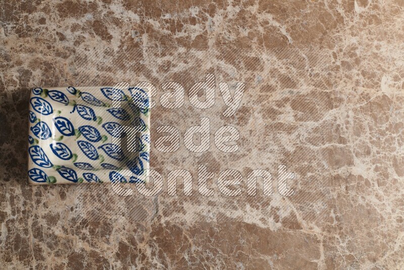 A decorative pottery plate on beige marble background