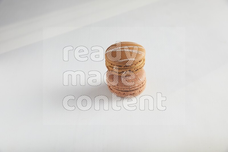 45º Shot of of two assorted Brown Irish Cream, and Brown Hazelnuts macarons on white background