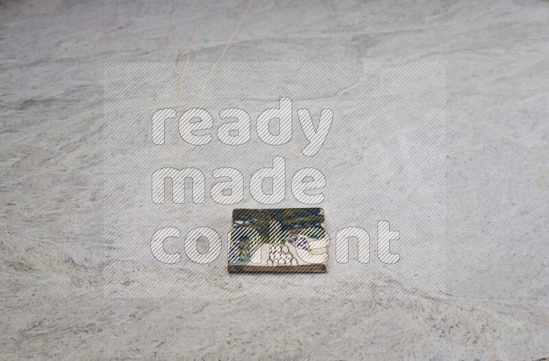 Top view shot of a pottery coaster\ tile on beige marble flooring
