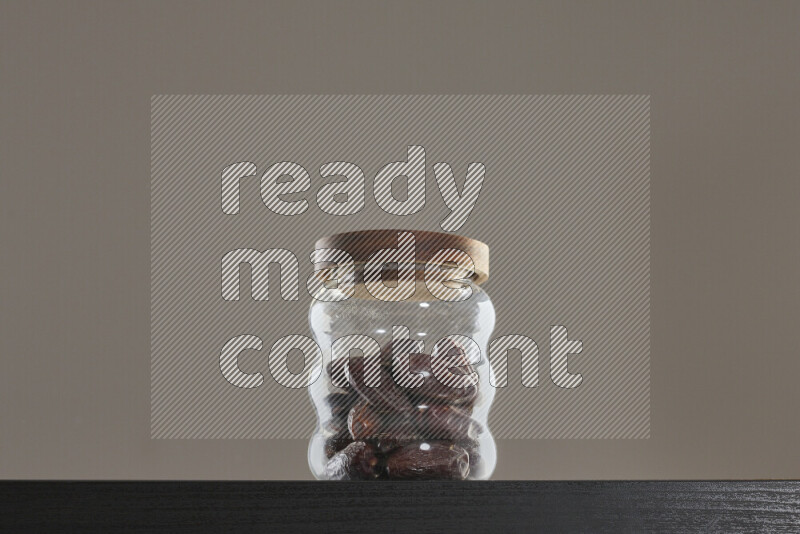 تمر في وعاء زجاجي على خلفية سوداء