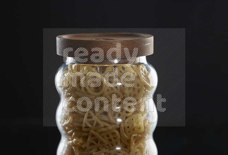 Snacks in a glass jar on black background