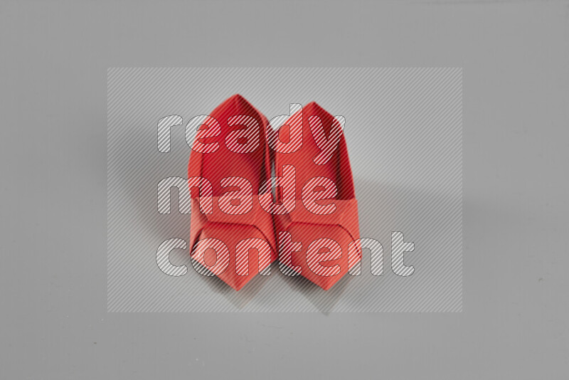 Origami shoes on grey background