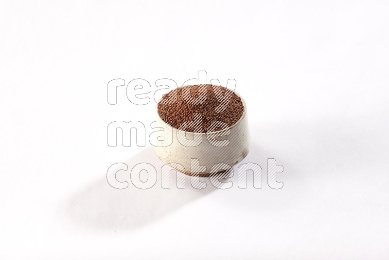 A beige pottery bowl full of garden cress seeds on a white flooring