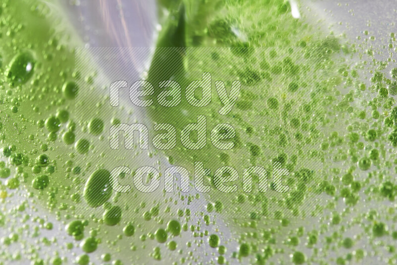 Close-ups of abstract green watercolor drops on oil Surface on white background