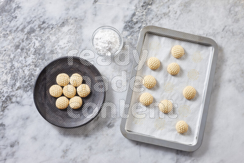 كحك خطوة بخطوة بمكوناته سمن، سكر، دقيق، سمسم، خميرة، ماء ونكهة الكحك على خلفية رخام رمادي